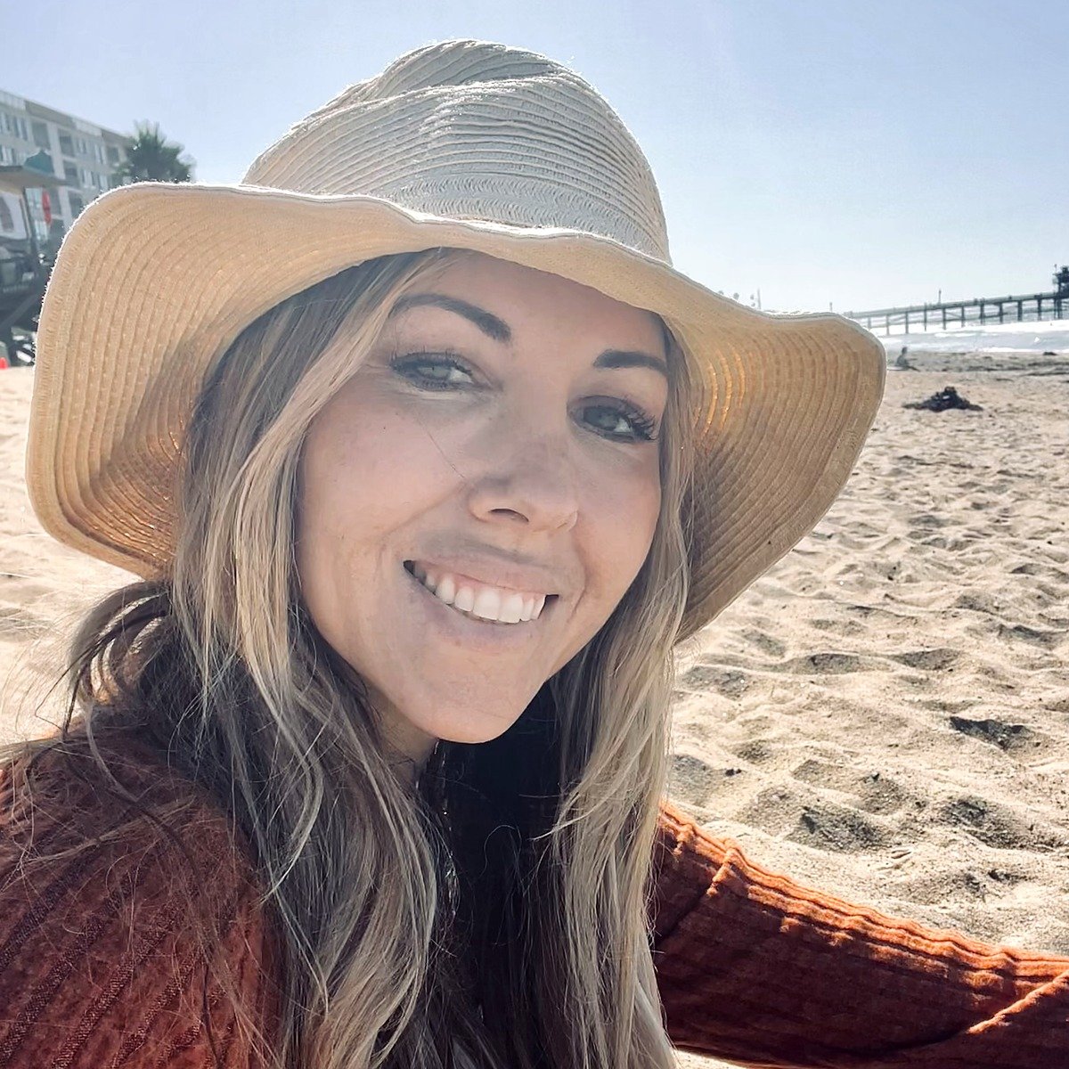 Erica Curtis in a straw hat on the beach in San Clemente, California